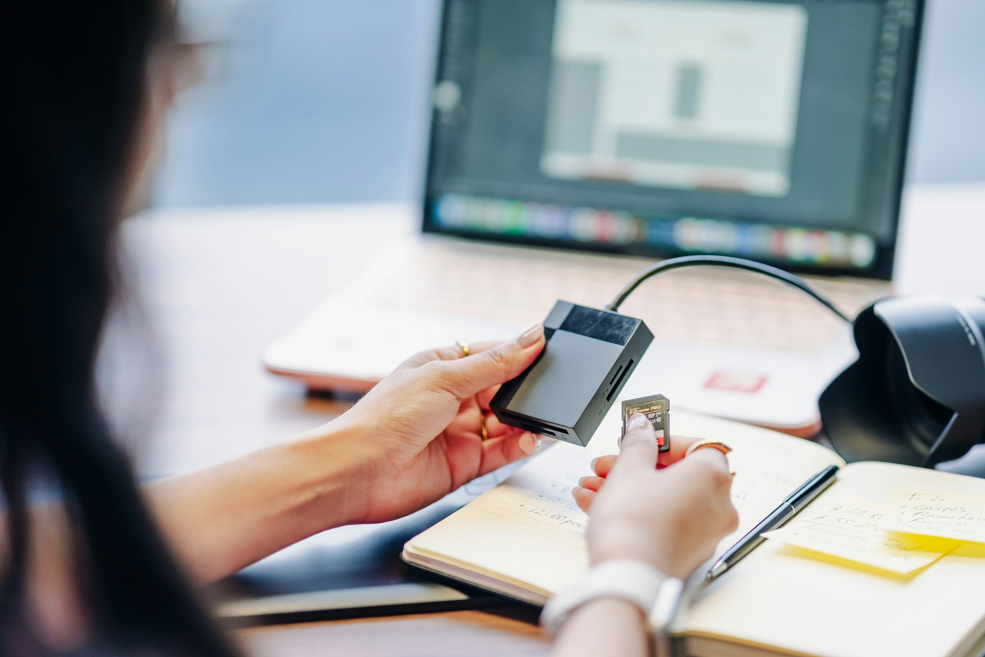 Woman inserting SD Card into A Laptop Dongle