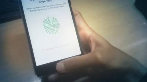Close up of a smartphone held in one hand with a fingerprint symbol on screen